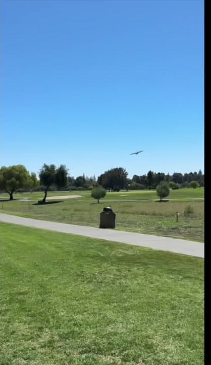 The airplane approaches the golf course.