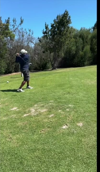 The golfer completes his swing.